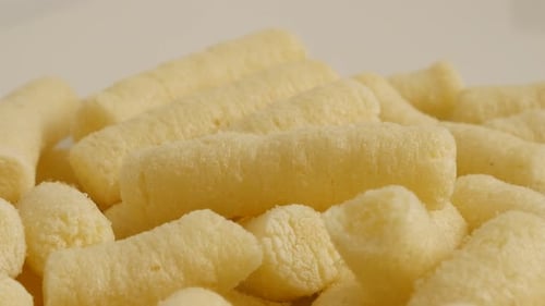 Tasty corn flips puffs unhealthy food close-up 4K 2160p 30fps UltraHD panning footage - Slow pan pu