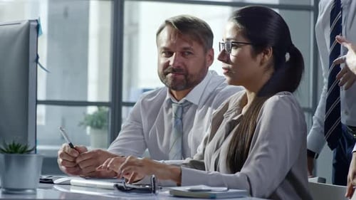 Team Discussing Computer Screen in Modern Workplace
