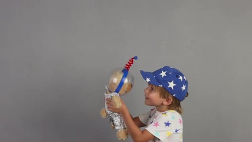 Boy Holding Teddy Bear Toy in Astronaut Costume