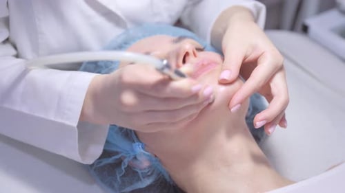 Woman Receiving Facial Treatment in Bright Clinic