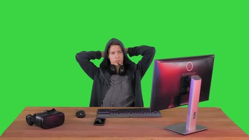 Hacker estressado e cansado do trabalho olhando para o monitor do PC em uma tela verde, Chroma Key.