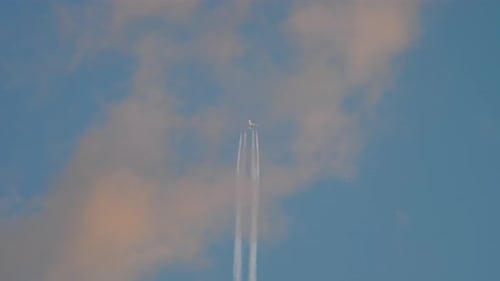 Jet Airplane Flying Leaving White Contrails in Blue Sky