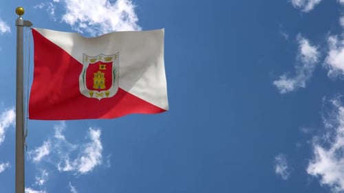 Waving Flag with Coat of Arms Against Blue Sky
