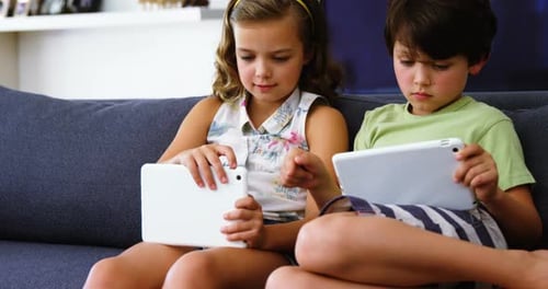 Children Play on Tablets on Comfortable Couch