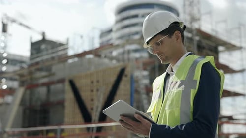 Architect in Helmet Using Tablet on Construction Site