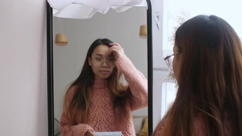 Mujer joven se pone una mascarilla quirúrgica para protegerse contra el brote de virus y la pandemia de COVID