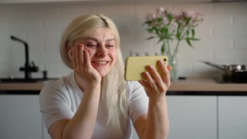 Happy Woman Video Calling on Phone at Home