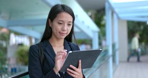 Young Woman Uses Tablet in Urban Setting