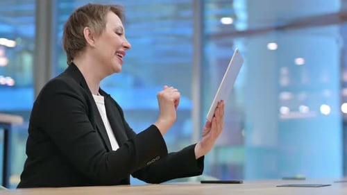 Excited Woman on Tablet Video Call in Office