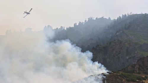 Airplane flies over wildfire to spot where to dump fire retardant