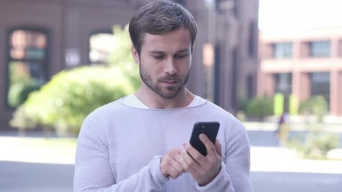 Portrait of Handsome Man Busy Using Smartphone