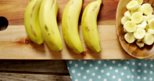 Fresh Bananas and Slices on Wooden Board