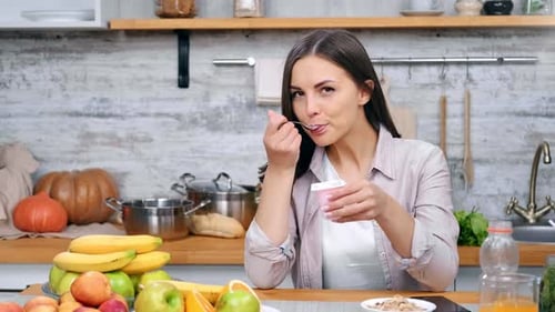 Young Woman Enjoys Yogurt and Fresh Fruit
