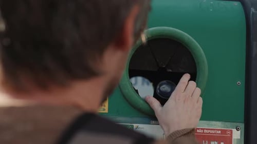 Adult Recycles Glass Bottle in Urban Environment