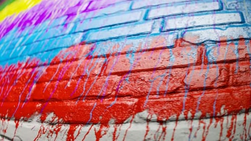 Vibrant Paint Dripping on Textured Brick Wall