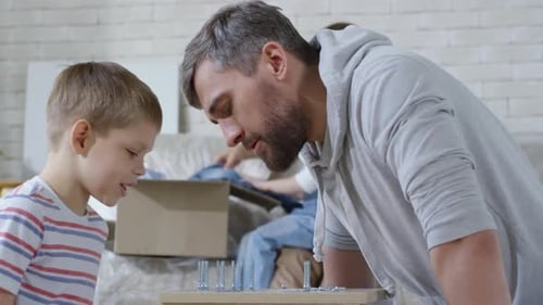 Father and Son Assembling Furniture Together at Home