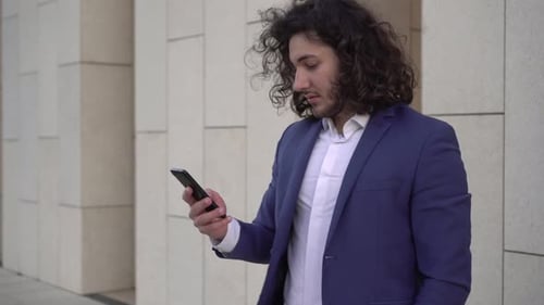 Young Adult Using Smartphone Outside Urban Building
