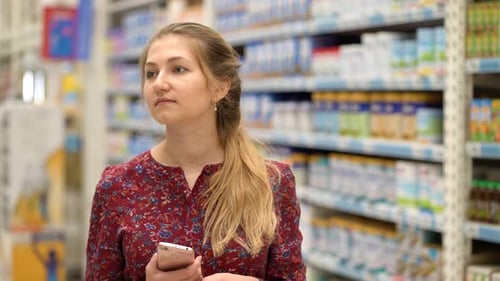 Attractive Young Woman Choosing Products in Supermarket Marketplace.