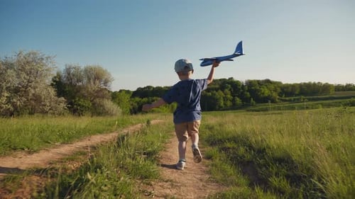 Child Runs With Airplane In Summer Field