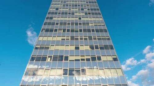 Modern office building and clouds in reflection, time-lapse