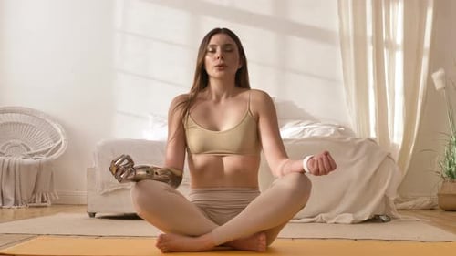 Woman with Bionic Arm Does Breathing Gymnastics Near Bed
