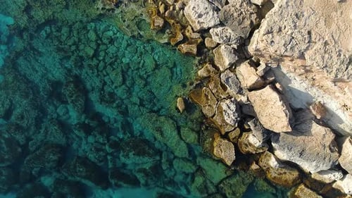 Rocky Cliff on the Seashore Aerial Top View Footage By Drone of Ocean Blue Water and Rocks Edge of