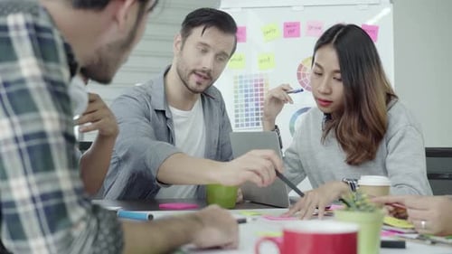 Gruppe lässig gekleideter Geschäftsleute, die im Büro über Ideen diskutieren