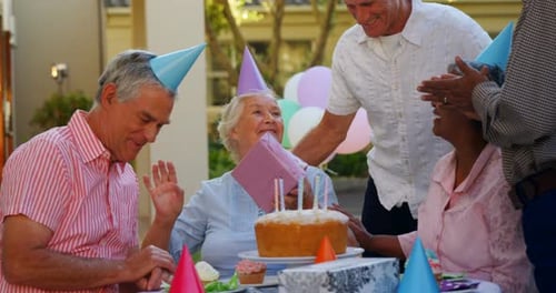 Smiling Seniors Celebrating Birthday Outdoors