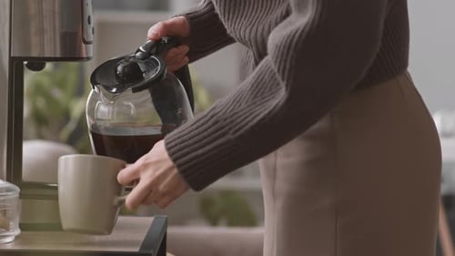 Woman Pouring Coffee in Office