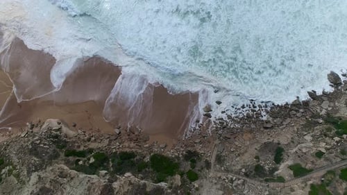 Aerial View of Waves Crashing on Beach Coastline