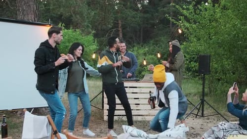 Friends Celebrate with Pizza and Dancing Outdoors