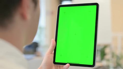 Young Man Using Tablet with Green Chroma Screen