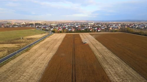 Luftaufnahme des Mähdreschers, der während der Erntezeit auf einem großen reifen Weizenfeld arbeitet