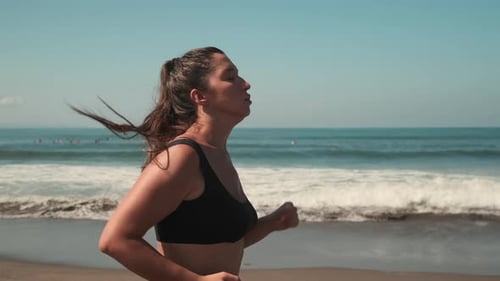Attractive Woman Jogging Along Golden Seacoast