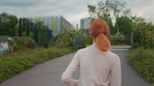 Back view of jogging woman in the park, morning sport.