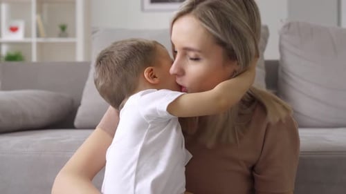 Blonde Woman Hugs Young Child with Affection