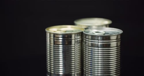 Three Silver Cans on a Black Background