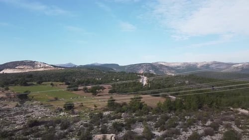 Workers Repairing Electrical Pylon in Rural Landscape