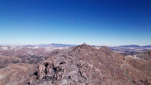 Vue aérienne d'un Drone en orbite autour d'un sommet rocheux et enneigé au-dessus de tout