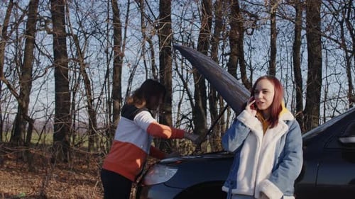 Women and Car Trouble near Woods in Daytime