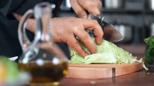 Chef Expertly Slicing Lettuce for Salad Preparation