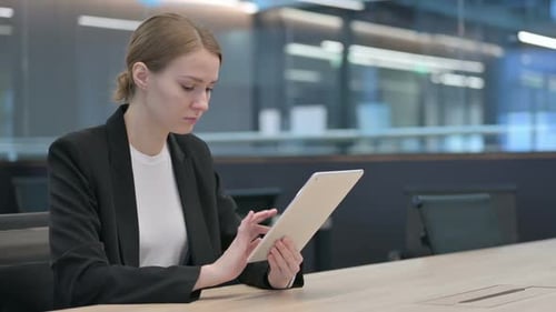 Businesswoman Works on Tablet in Modern Office