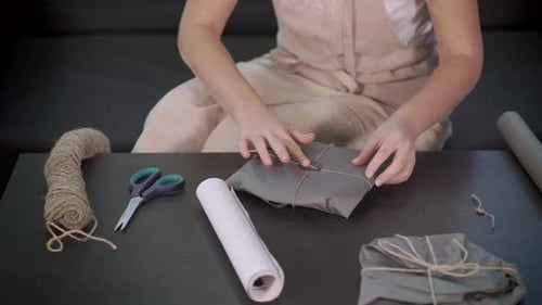 Craft Woman Is Fixing Stickers on Packing with Handmade Items, Close-up of Hands