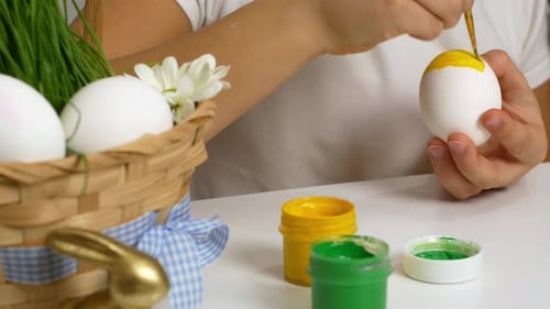 Child Paints Easter Egg Yellow