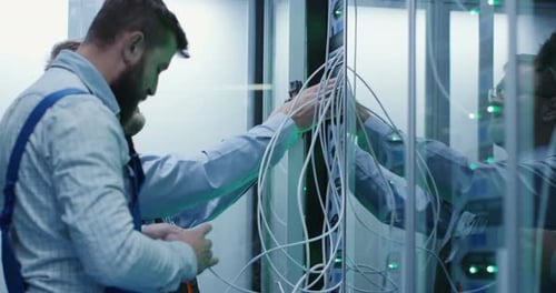 Two Male Technicians Working in a Data Center