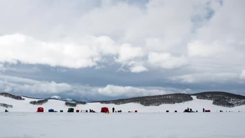 Lapso de tiempo de personas pescando en hielo en un paisaje congelado