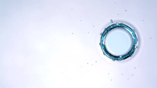 Blue Liquid Droplet Impacts Surface Creating Splash