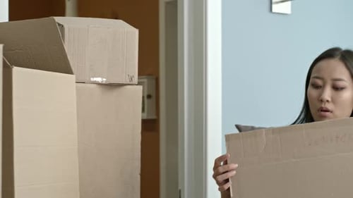 Young Woman Packing and Moving Boxes Indoors
