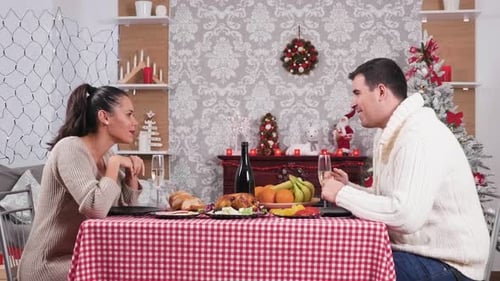 Festive Couple Celebrating Christmas with Champagne Dinner