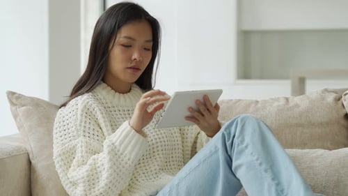 Young Adult Relaxing with Tablet at Home